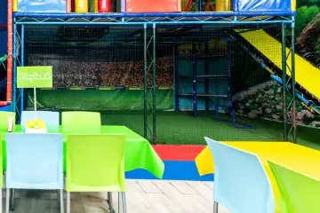 Cancha techada de pasto sintético de Playland, con el mural de gradas de estadio al fondo