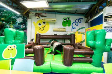 Toro mecánico de Playland dentro de un corral inflable con troncos y cactus verdes
