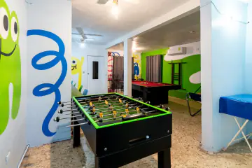 Futbolito de Playland en primer plano y, al fondo, la mesa de billar y los murales de la marca